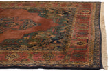 Vintage Indian Serapi rug corner, abrashed terra cotta field, floral vine border, ivory fringe.