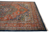 Denim blue selvage, ivory fringe, and terra cotta samovar turtle border of Indian Heriz carpet.