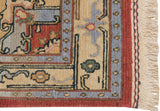 Indian Serapi Soumac rug corner with brick red and slate blue borders and beige fringe.