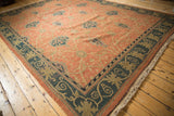 Terra cotta Arts and Crafts rug with navy floral palmettes and beige vinery.