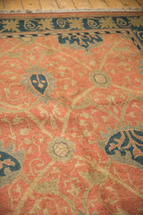 Terra cotta Soumac rug with germinating plant and dusty navy palmette motif.