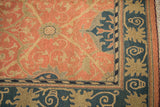 Corner of Indian Soumac rug with terra cotta field, navy border, and original selvage.
