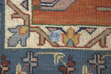 Vintage Indian Serapi rug's hand-knotted pile and geometric blue, rust, beige pattern.