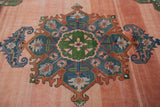 Bold geometric stylized motif featuring denim blue and rust on abrashed blush field.