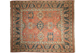 Vintage Serapi Soumac carpet, dusty blush field with asymmetric floral patterns and dark navy border.