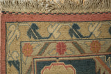 Hand woven Indian Serapi Soumac carpet corner with dusty blush border and navy floral motifs.