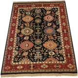Indian Serapi Soumac carpet corner with beige fringe, wine red border, and black field palmettes.