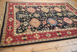 Vintage Serapi Soumac carpet corner with wine red border and black field floral palmettes.