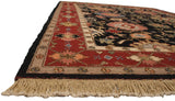 Intact side selvage, wine red floral border, black field with palmettes, and natural fringe.