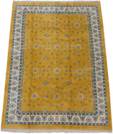 Saffron yellow Indian Art Deco carpet with repeating floral and star motifs in blue.