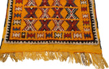 Corner detail of a Moroccan rug showing the full pile, secured selvage, and saffron fringe.