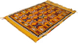 Angled view of a vintage Murat rug highlighting its plush saffron pile and geometric pattern.