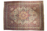 Antique Kermanshah carpet with a concentric starburst medallion and sprawling vinery in ivory, red, and navy.
