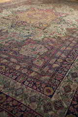 Layered floral borders and scalloped medallion detail on an antique Persian Kermanshah carpet.