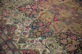 Storied texture of an antique Kermanshah rug, with a low pile revealing the intricate, hand-knotted floral design.
