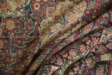 Storied, hand-knotted texture of a draped antique Persian carpet with floral and vinery details.