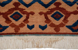 Turkish rug border displays sapphire blue and terra cotta geometric patterns, with cream fringe.