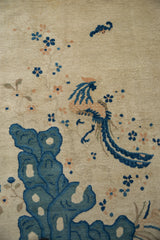 Detailed pictorial phoenix, blue scalloped bluff, and delicate florals on an antique Peking rug.