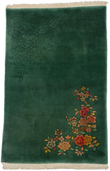 Vibrant red, orange, yellow blooms in corner of emerald green vintage Chinese Art Deco rug.