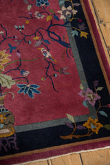Nichols Art Deco pictorial rug detail: rich blush field, dark navy branch with colorful bird.