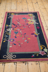 Infinity knot motif with blush floral details on a vintage Nichols Art Deco rug.