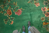 Emerald green Art Deco carpet with oversized blush, wine, saffron floral sprays, underfoot.