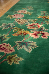 Oversized floral sprays in blush, wine, and saffron on emerald green Art Deco carpet.