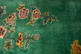Intricate blush, ivory, saffron floral sprays on emerald green field of vintage Nichols Art Deco rug.