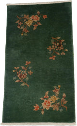 Embossed floral sprays with rust and ivory hues on a dark green Nichols Art Deco rug pile.