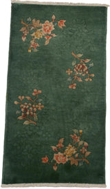 Embossed floral spray with rust and ivory tones on the dark green Nichols pile.
