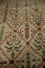 Vintage Agra carpet close-up: hand-knotted ivory trellis with wine red, olive, and aqua plant motifs.