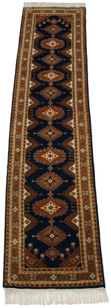 Repeating contour medallions and geometric borders in navy, rust, and ivory on a vintage Turkmen runner.