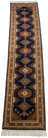 Indian Turkmen design rug runner showing cream fringe and rust-toned geometric hook motifs.