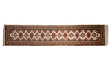 Vintage Indian Turkmen runner with repeating ivory, rust, navy geometric medallions.