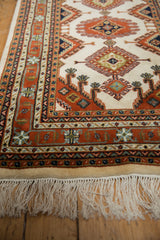 Vintage Indian Turkmen hand-knotted rug's rust, navy, and ivory geometric border.
