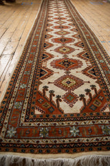 Rust contour medallions, hook and latch motifs, and geometric border on this full pile Turkmen runner.
