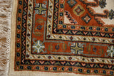 Vintage Indian Turkmen runner corner showcasing rust, navy, ivory borders with hook and latch motifs.