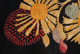 Detail of Art Deco rug showing golden starburst and raspberry floral motifs, deep pile.