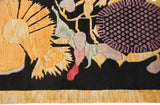 Detail of Art Deco rug with gold starburst floral, mauve patterns, muted green, and fringe.