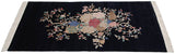 Dense Art Deco floral arrangement with roses and vinery on a rich navy black ground.