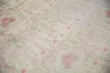 Muted tones and distressed texture of a vintage Kerman design carpet's floral pattern.