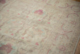 Angled close-up of the distressed Kerman design carpet's softened ivory and raspberry floral pile.