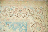 Softly faded floral arabesques and low, even pile on the corner of a vintage rug.