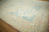 Worn, low pile on a distressed Polonaise carpet with sky blue and cream floral arabesques.