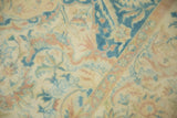 Close-up showing the even wear and floral arabesques in sky blue and dusty rose.