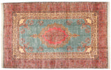 Vintage Persian Kerman carpet with a scalloped pink medallion and floral sprays on a dusty powder blue field.