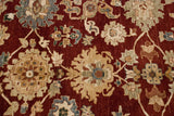 Close view of the contoured palmette motifs in beige, silver, and copper on a cherry red field.