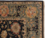 Corner view of a new Agra carpet with its slate blue, terracotta, and charcoal arabesque border.