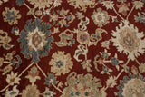 Oversize palmette floral motifs in wheat and silver against a lush cherry red hand-knotted pile.