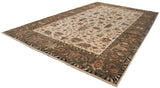 Angled perspective of the Indian Serapi carpet's ivory field, sprawling vinery, and wide olive border.